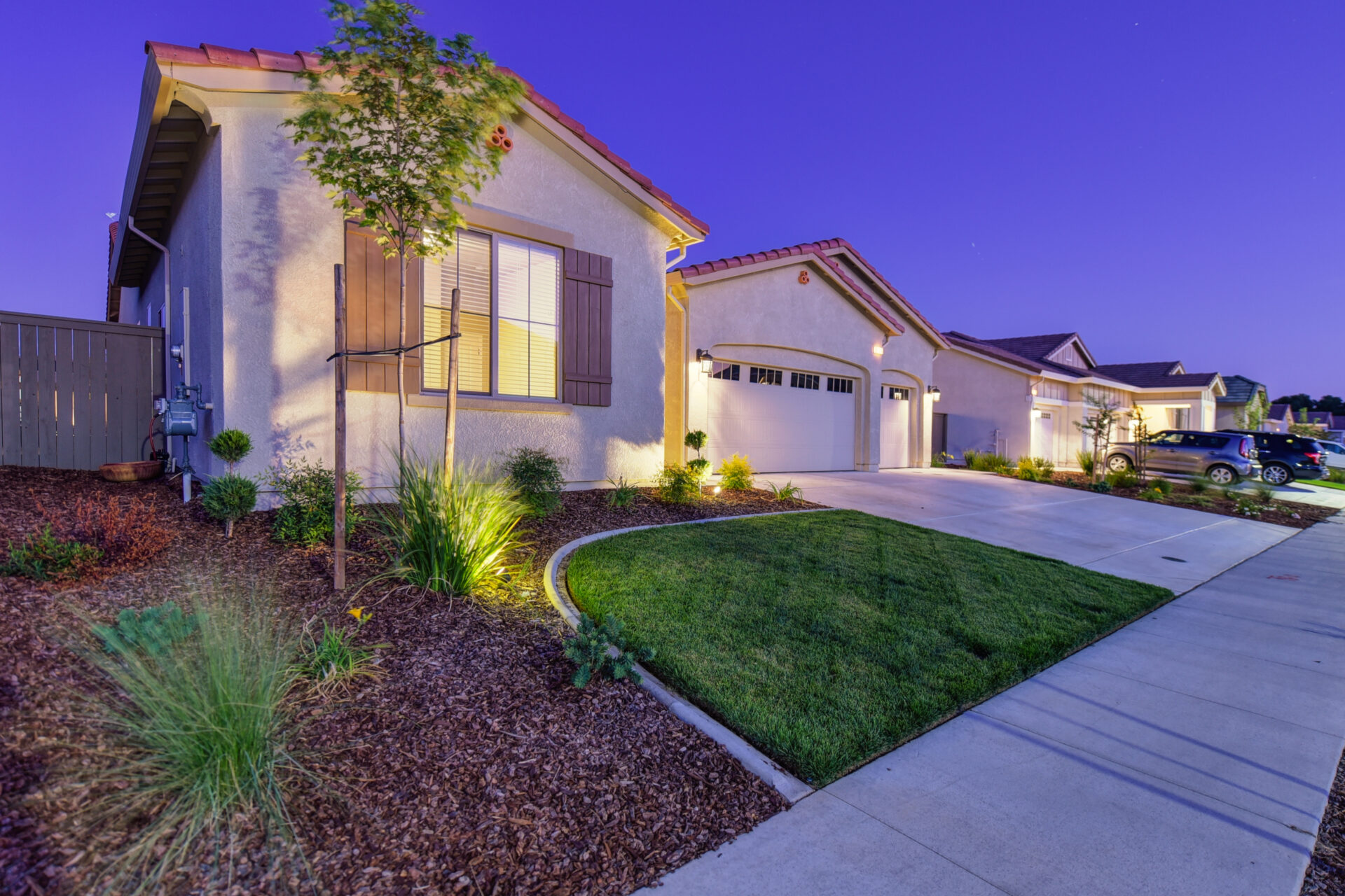 A home with grass and bushes in front of it.