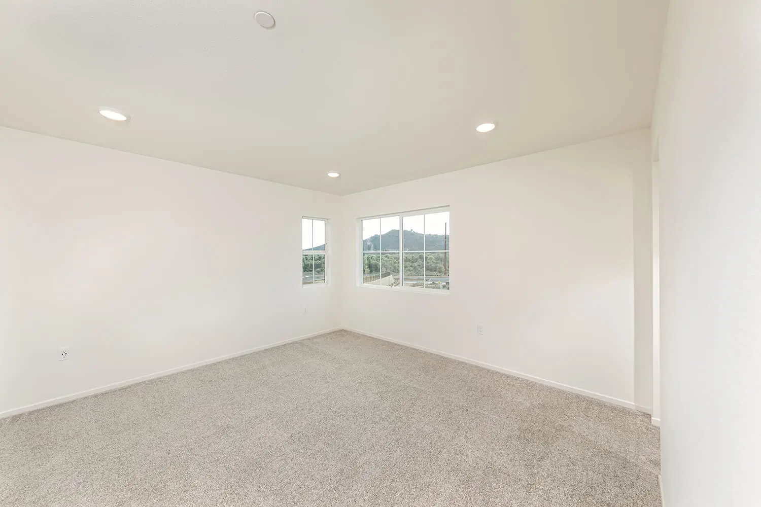 A room with a large window and carpet.