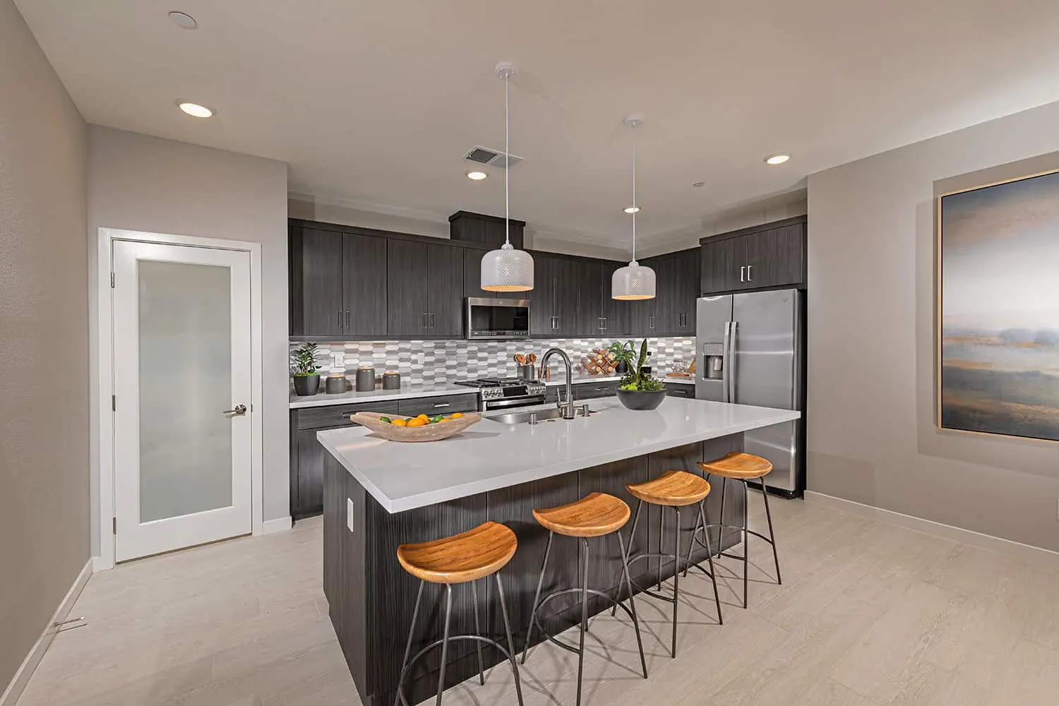 A kitchen with an island and a refrigerator.