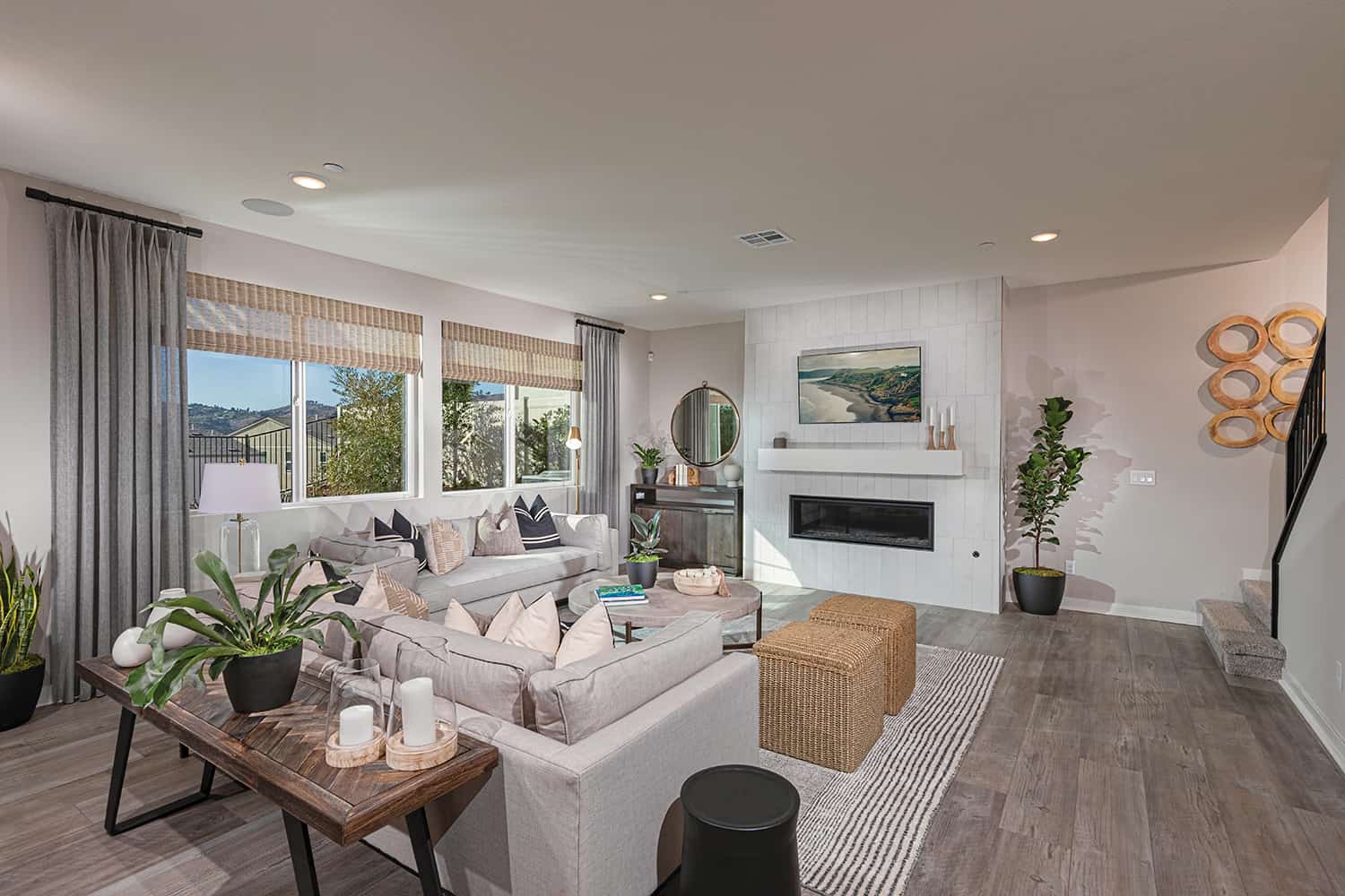 A living room with white furniture and wood floors.