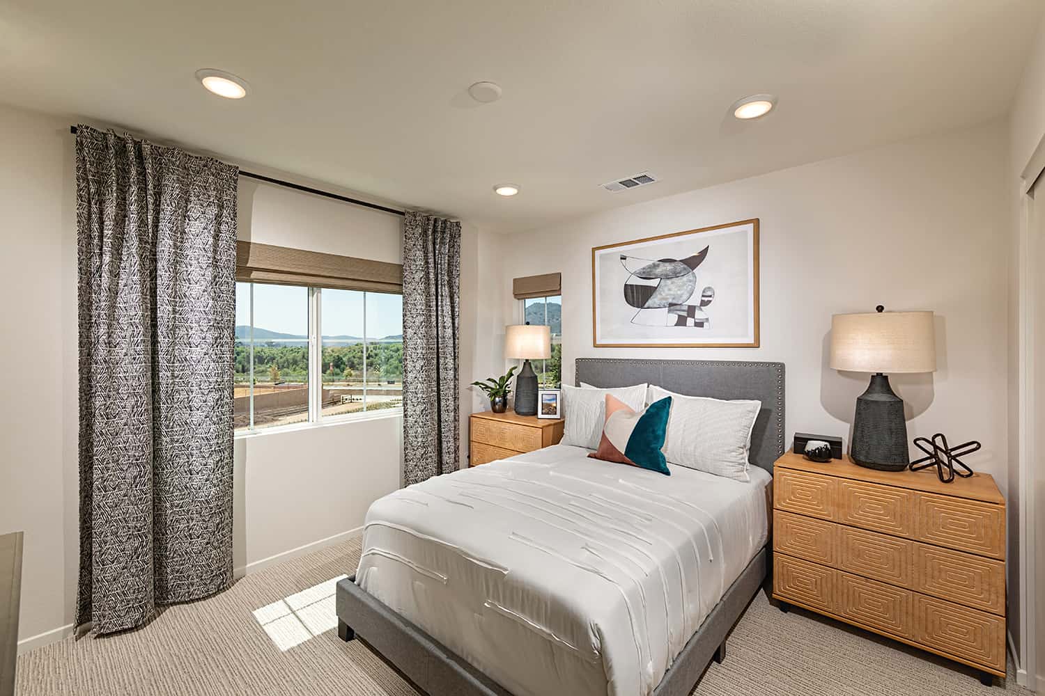 A bedroom with a bed, nightstands and window.