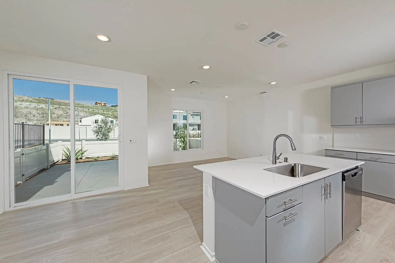 A kitchen with white walls and wooden floors.