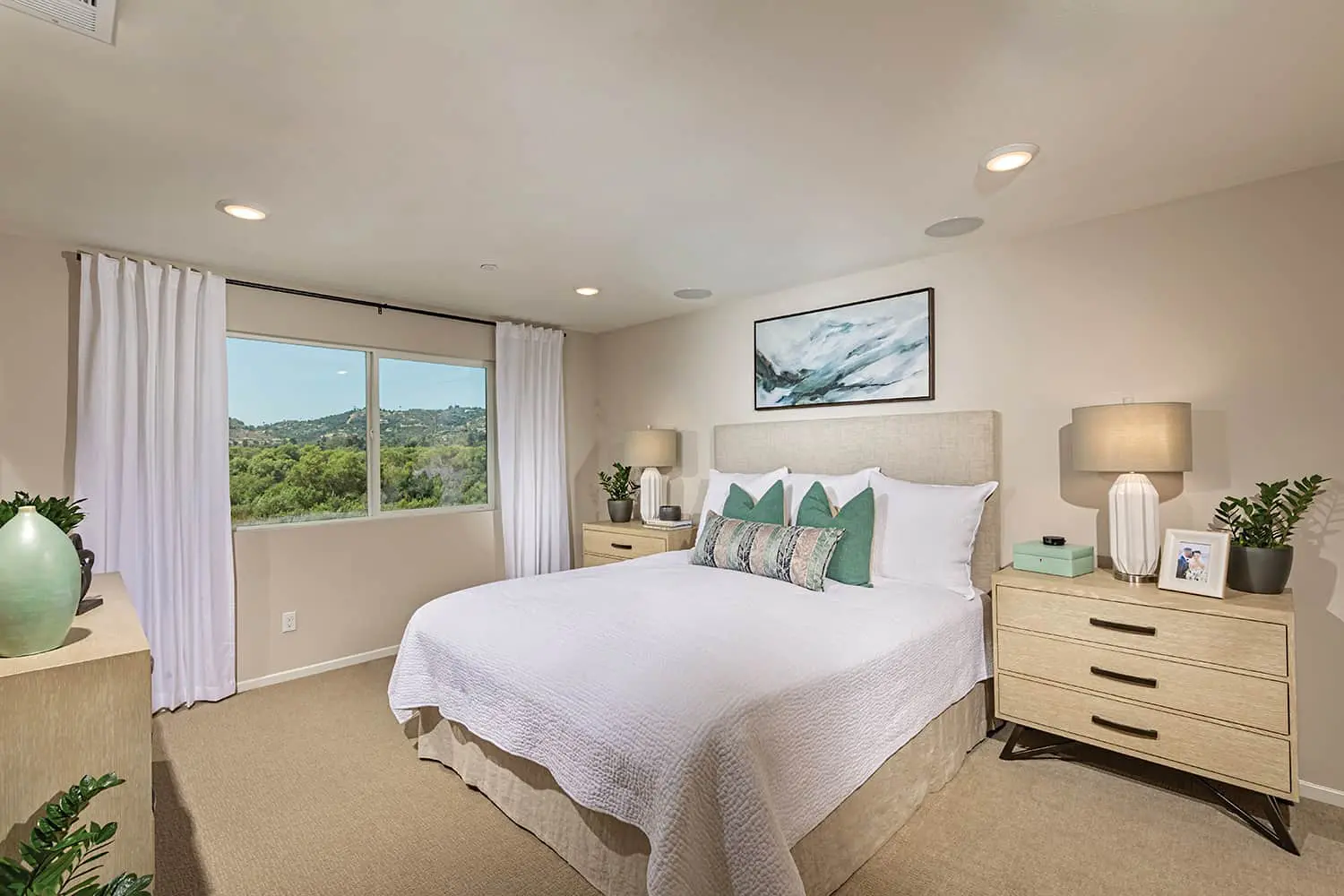 A bedroom with a large bed and two nightstands.