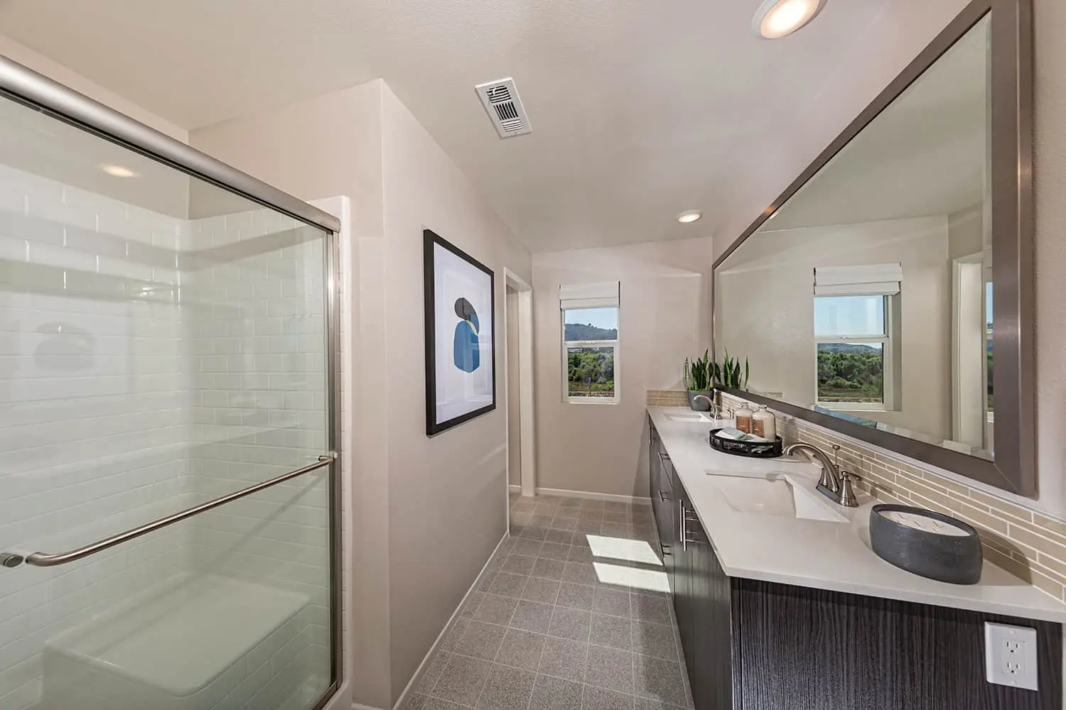 A bathroom with two sinks and a shower.