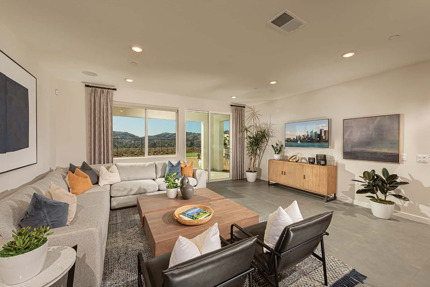 A living room with couches and chairs, a table and a television.