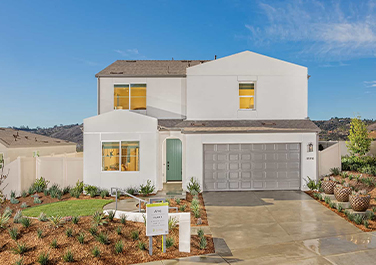 A white house with a green door and garage.