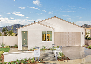 A white house with a garage and steps leading to it.