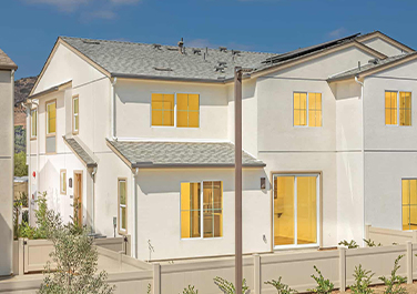 A white house with yellow windows and shutters.