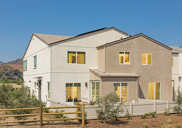 A large white house with yellow windows and shutters.